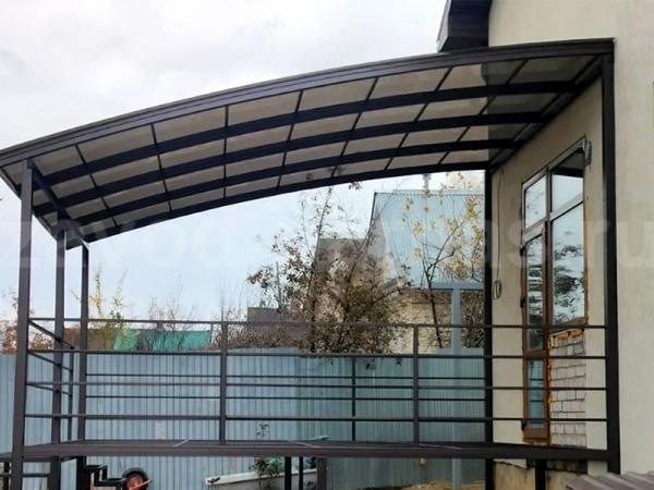 Терраса с полупрозрачной арочной крышей и металлическим каркасом